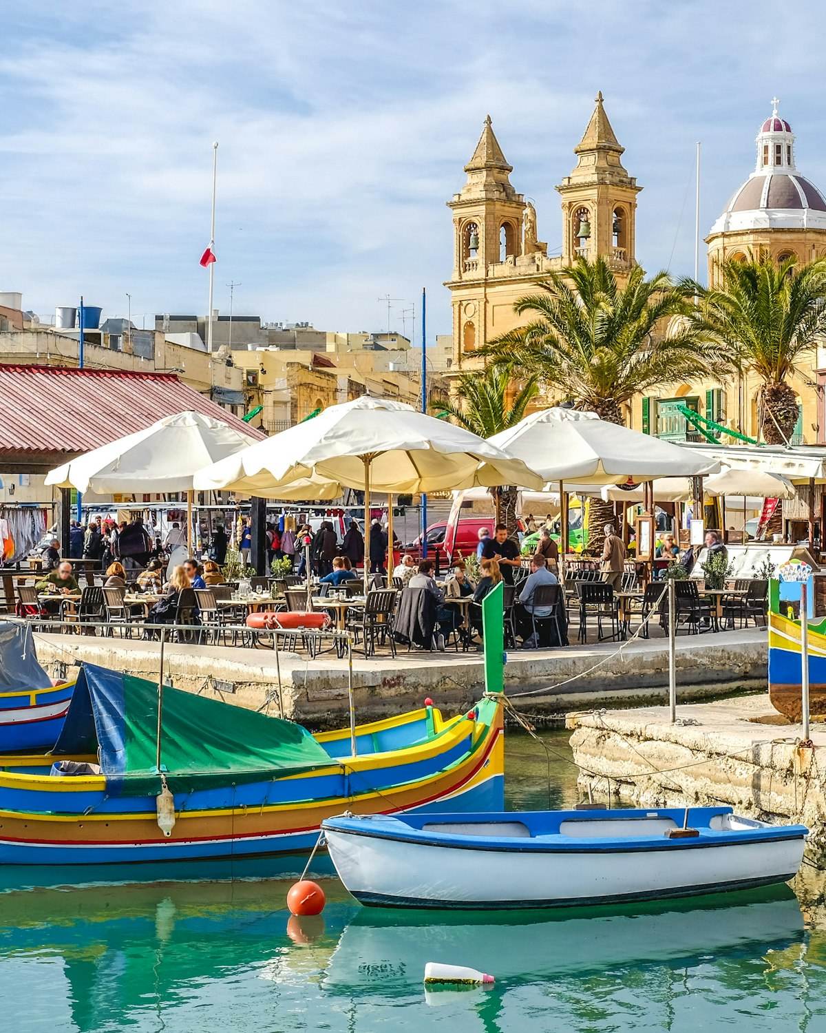 Maltese harbour with a church and boats