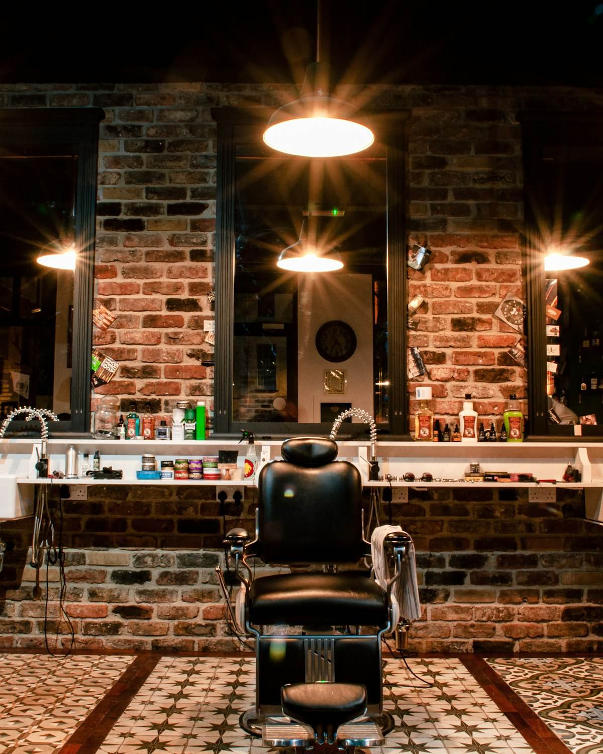 Black leather barber chair against a brick wall